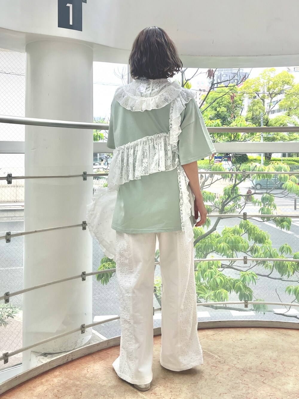 グリーン系のTシャツ/カットソー、ホワイト系のトートバッグ、ホワイト系のデニムパンツを着用したレディースの春コーディネートの3枚目の写真