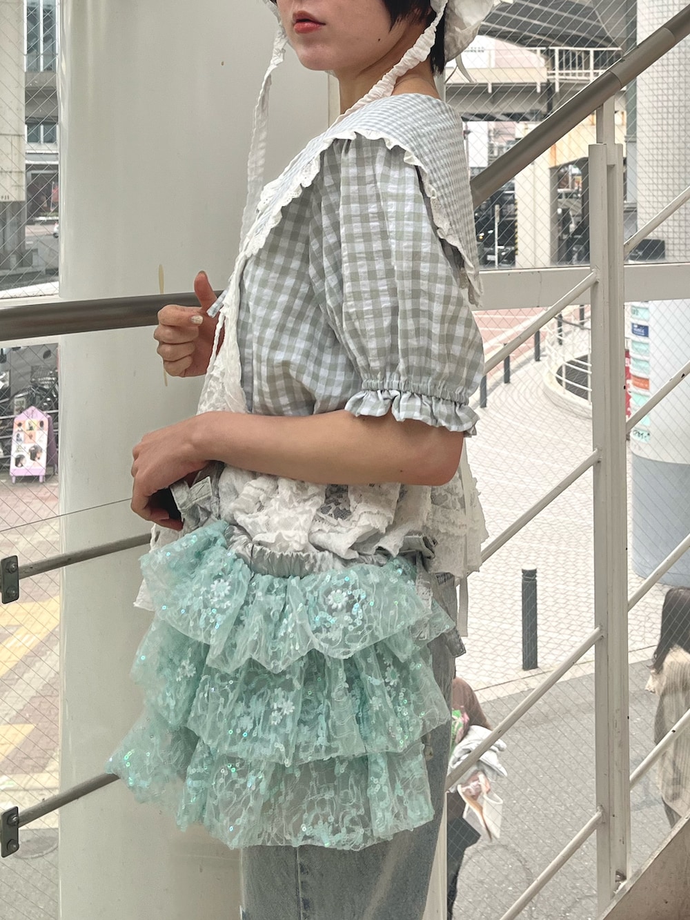 ホワイト系のキャミソール、グリーン系のシャツ/ブラウス、ブルー系のショルダーバッグを着用したレディースの春コーディネートの5枚目の写真