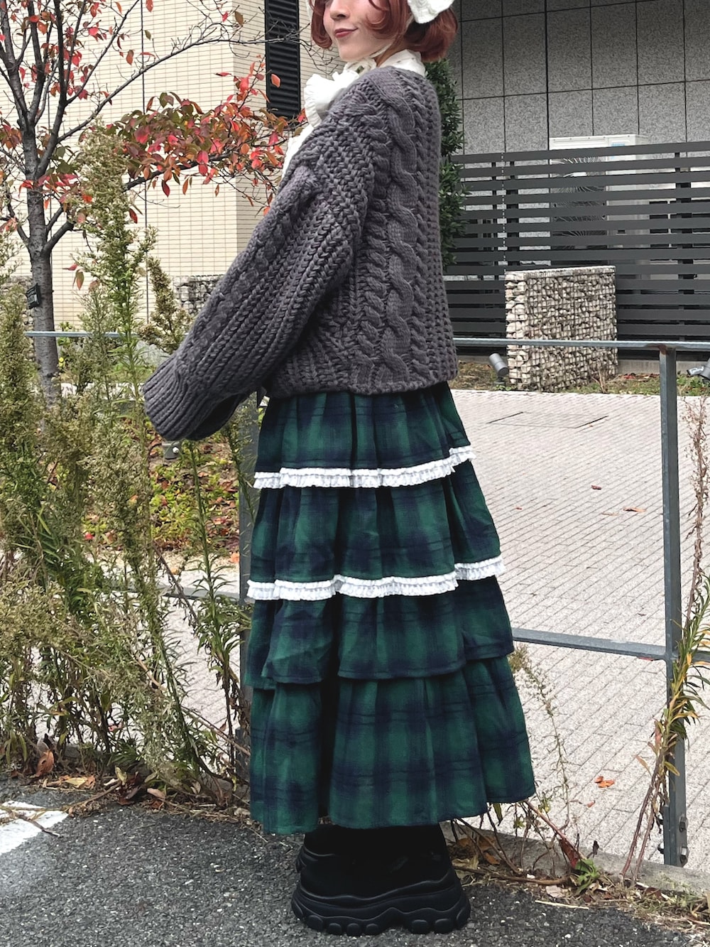 グリーン系のスカート、グレー系のカーディガン/ボレロ、ホワイト系のシャツ/ブラウスを着用したレディースの秋コーディネートの3枚目の写真