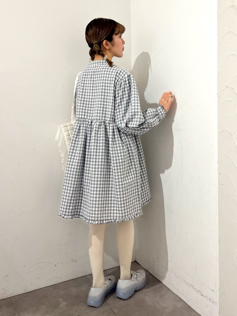 グレー系のワンピース、ホワイト系のトートバッグ、ブルー系のスニーカーを着用したレディースの春コーディネートの9枚目の写真