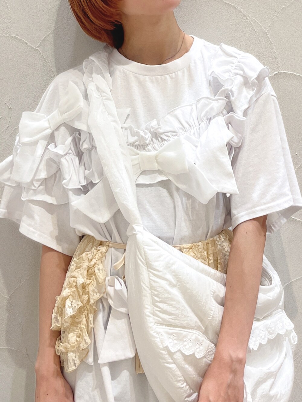 ホワイト系のショルダーバッグ、ホワイト系のTシャツ/カットソー、ブルー系のスラックスを着用したレディースの夏コーディネートの7枚目の写真