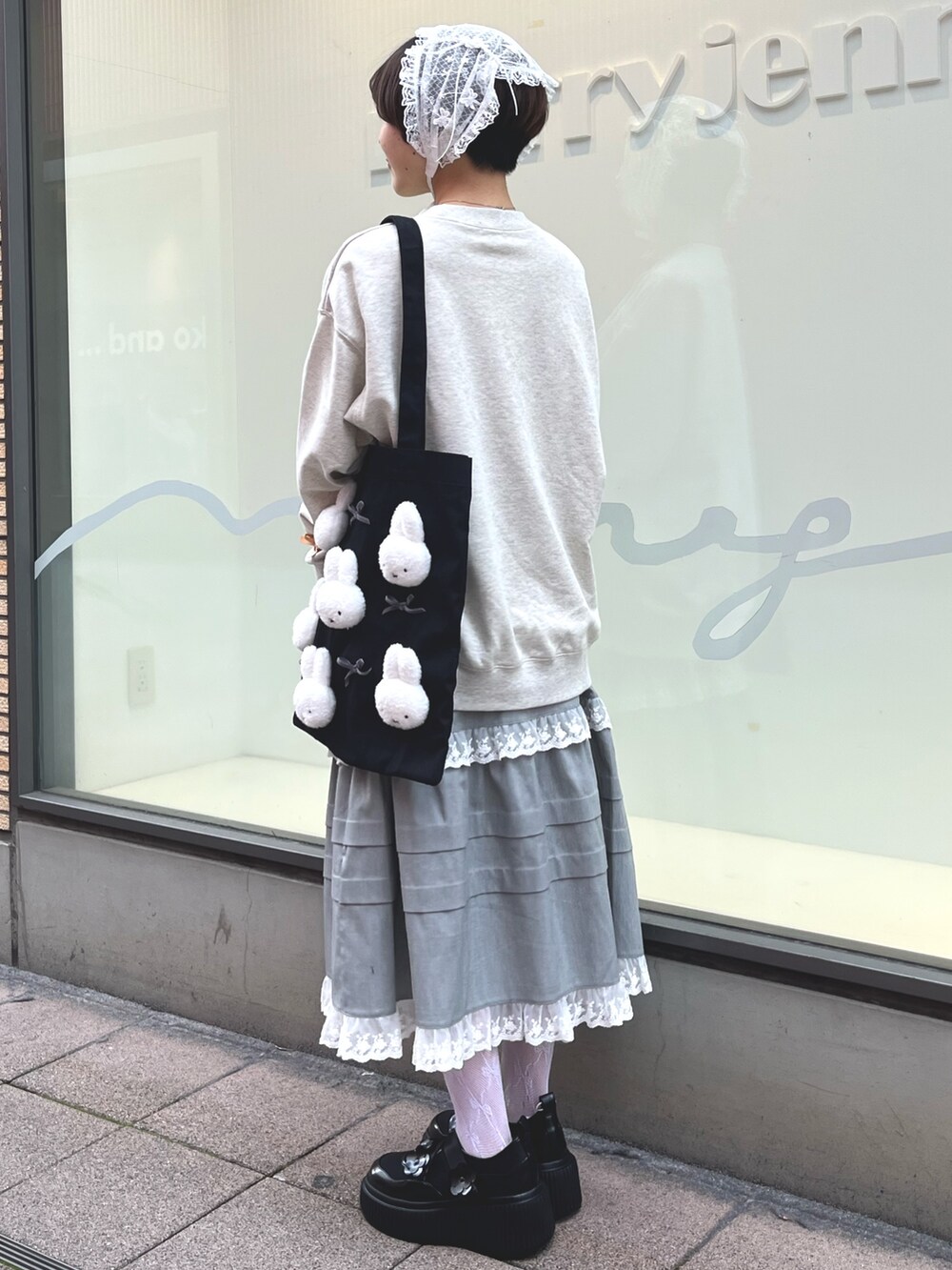 グレー系のスウェット、グレー系のスカート、ブラック系のスニーカーを着用したレディースの冬コーディネートの5枚目の写真