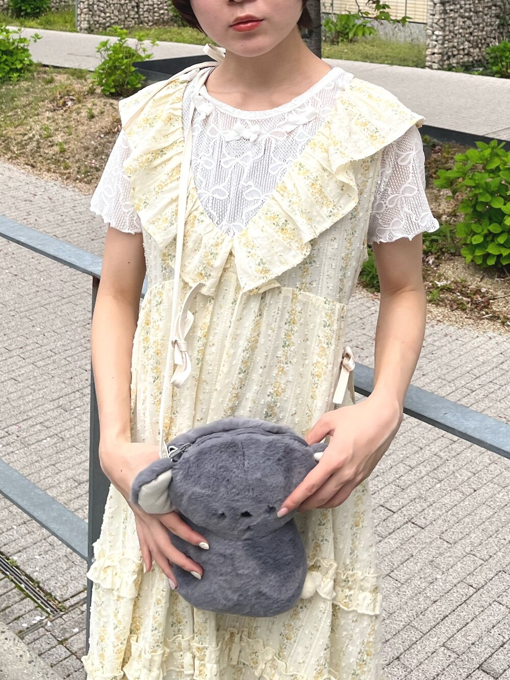 イエロー系のワンピース、ホワイト系のTシャツ/カットソー、グレー系のショルダーバッグを着用したレディースの春コーディネートの4枚目の写真