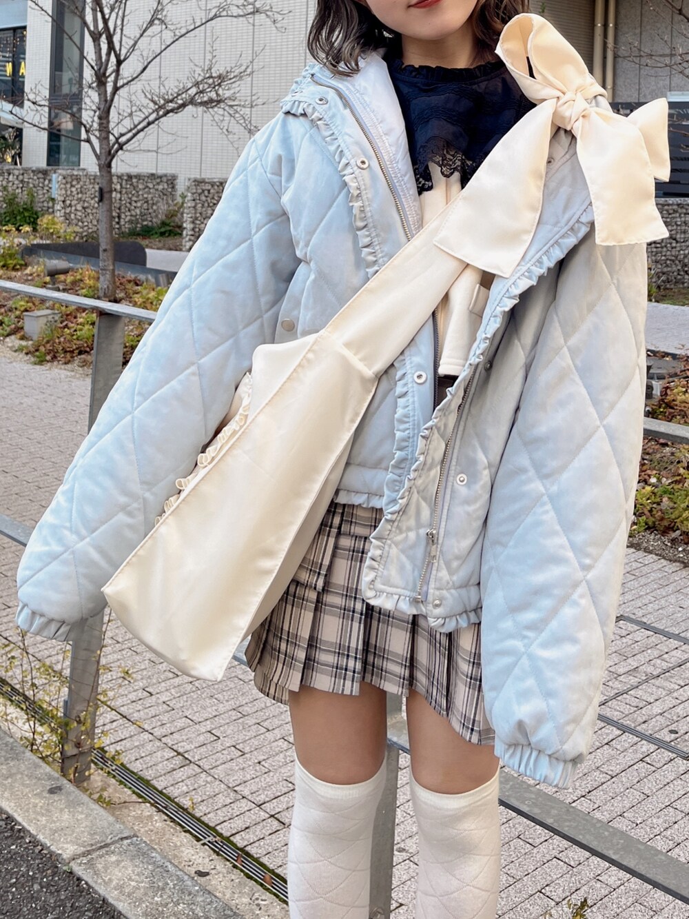 ブルー系のダウンジャケット/コート、ベージュ系のスカート、ホワイト系のトートバッグを着用したレディースの冬コーディネートの2枚目の写真