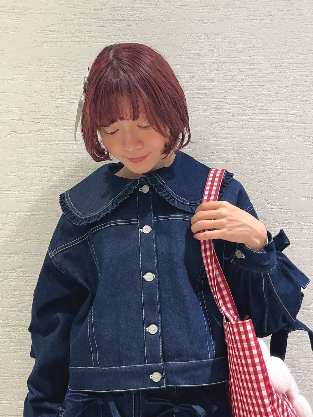 ブルー系のスカート、ブルー系のデニムジャケット、レッド系のトートバッグを着用したレディースの秋コーディネートの5枚目の写真