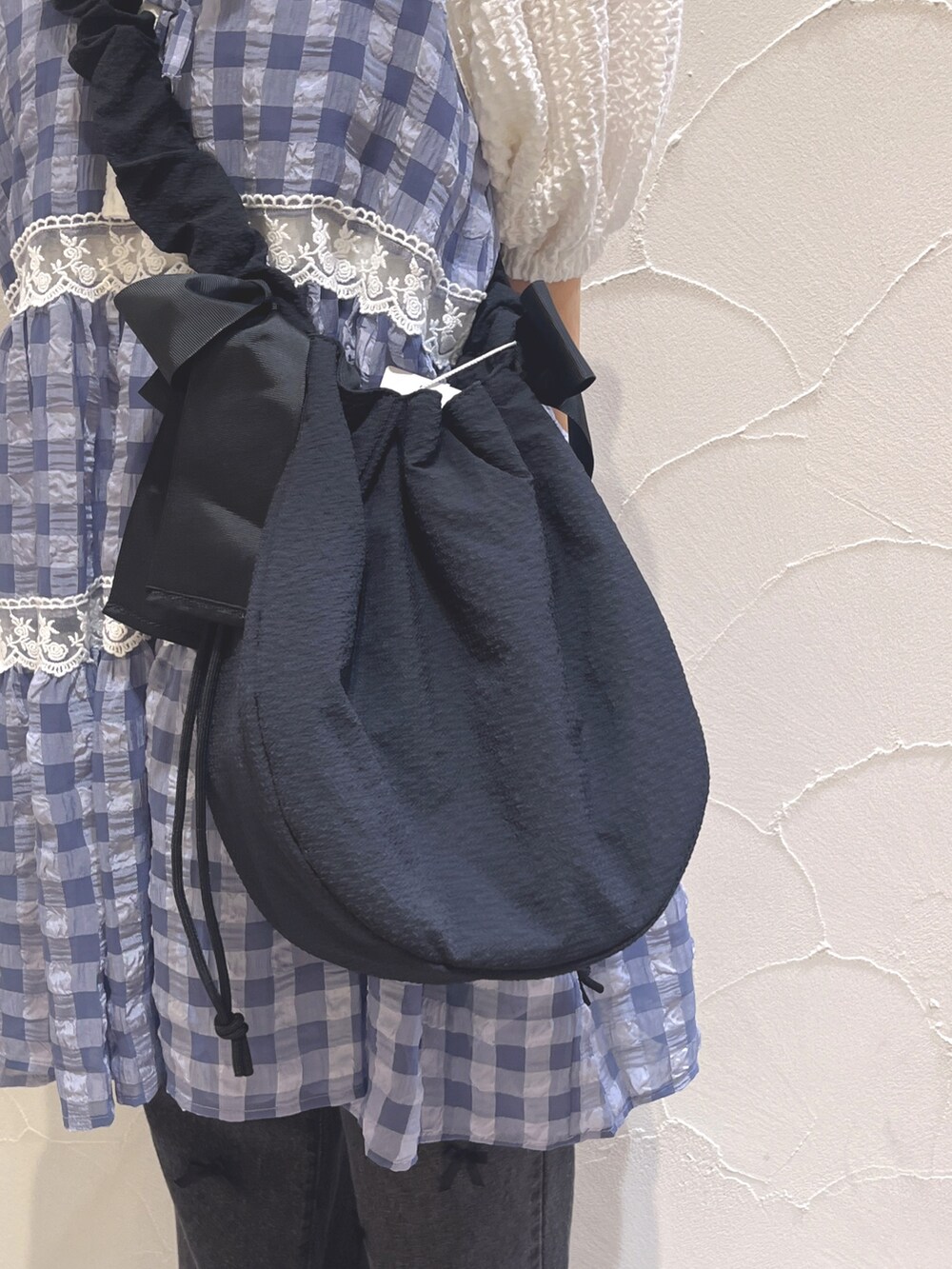 ホワイト系のシャツ/ブラウス、ブルー系のキャミソール、ブラック系のショルダーバッグを着用したレディースの夏コーディネートの8枚目の写真