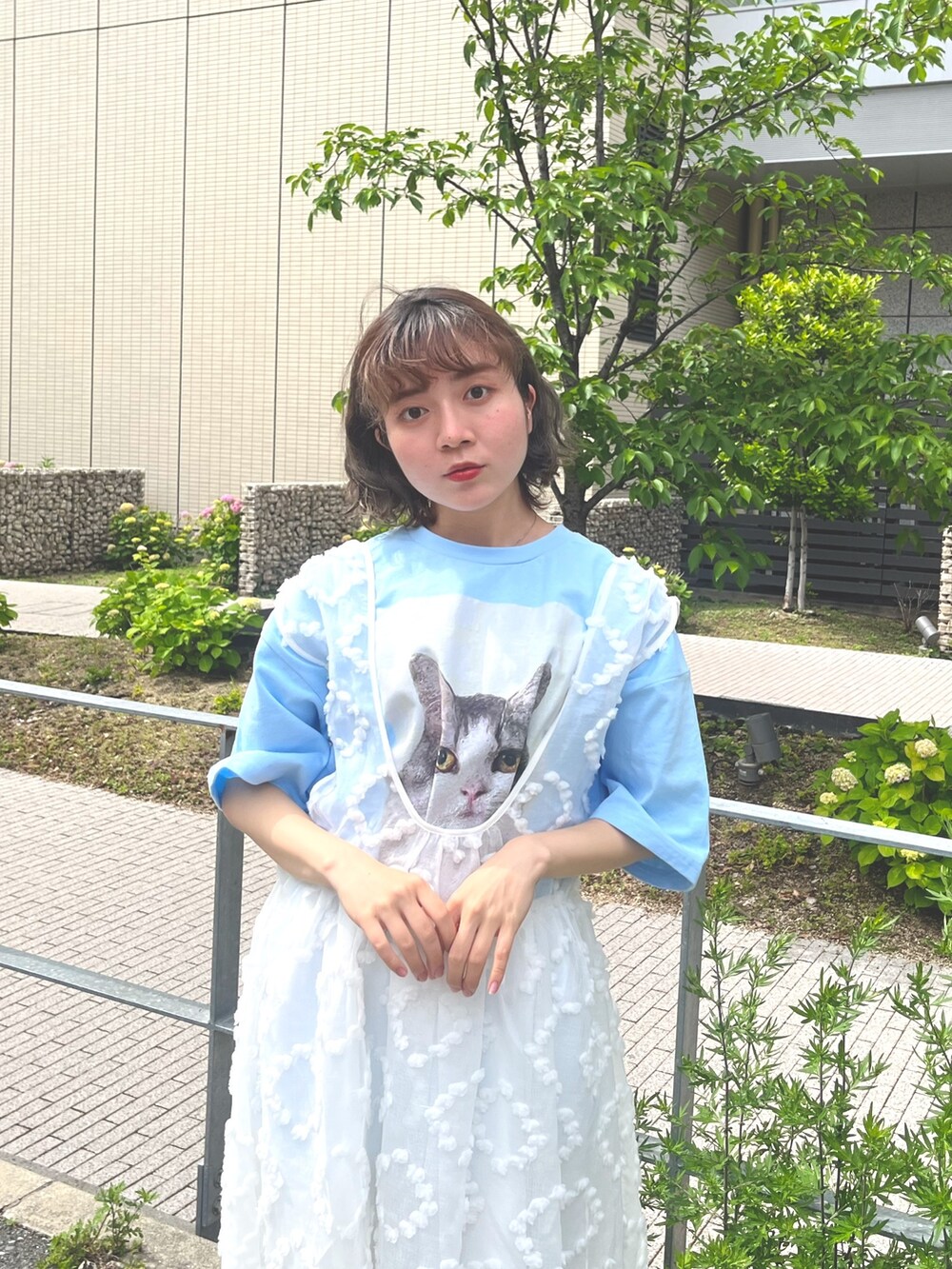 ホワイト系のジャンパースカート、ブルー系のTシャツ/カットソー、ブルー系のデニムパンツを着用したレディースの春コーディネートの5枚目の写真