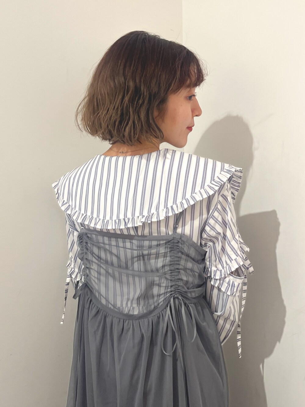 グレー系のワンピース、ホワイト系のシャツ/ブラウス、シルバー系のバレエシューズを着用したレディースの夏コーディネートの7枚目の写真