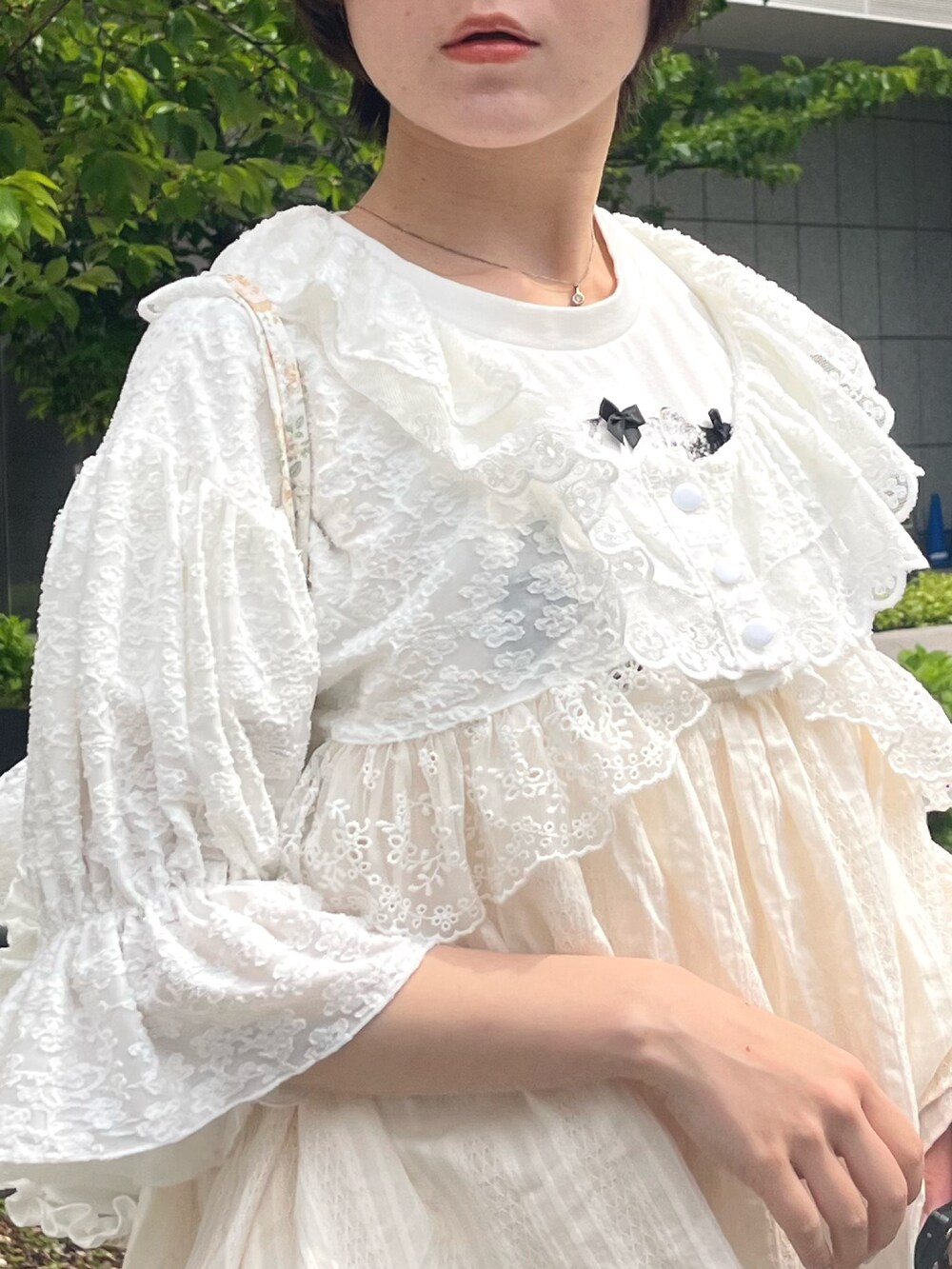 ホワイト系のスニーカー、イエロー系のバックパック/リュック、ホワイト系のカーディガン/ボレロを着用したレディースの春コーディネートの5枚目の写真