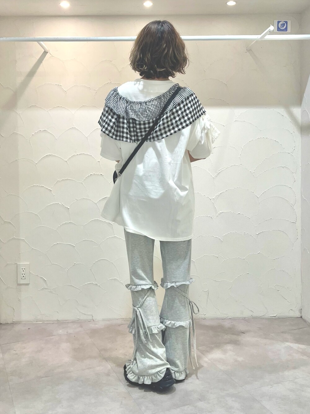 ホワイト系のTシャツ/カットソー、ブラック系のショルダーバッグ、グレー系のスウェットパンツを着用したレディースの春コーディネートの4枚目の写真