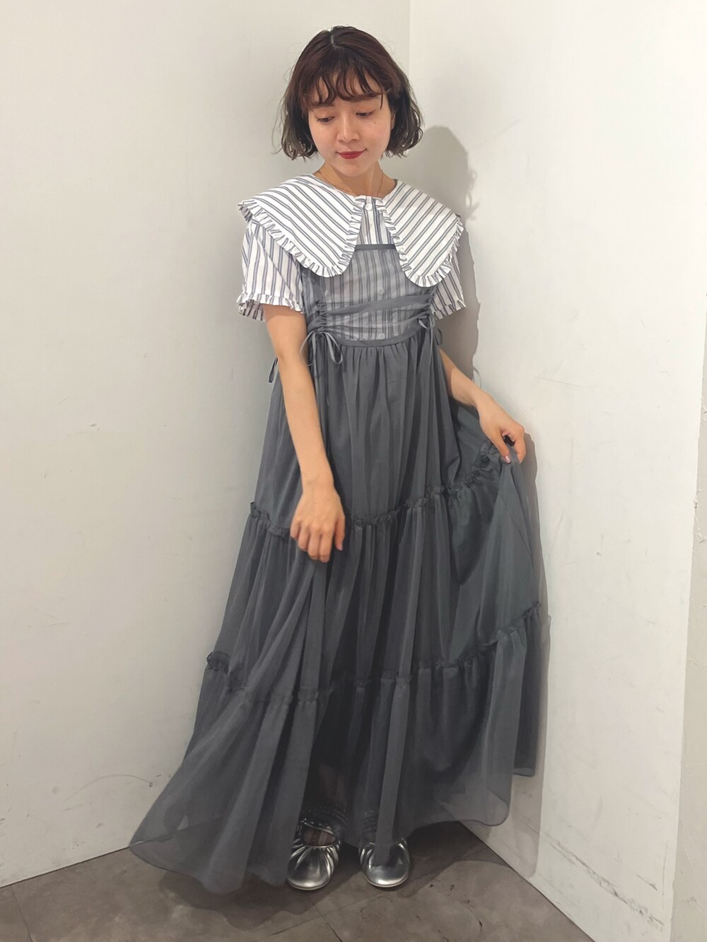 グレー系のワンピース、ホワイト系のシャツ/ブラウス、シルバー系のバレエシューズを着用したレディースの夏コーディネートの4枚目の写真