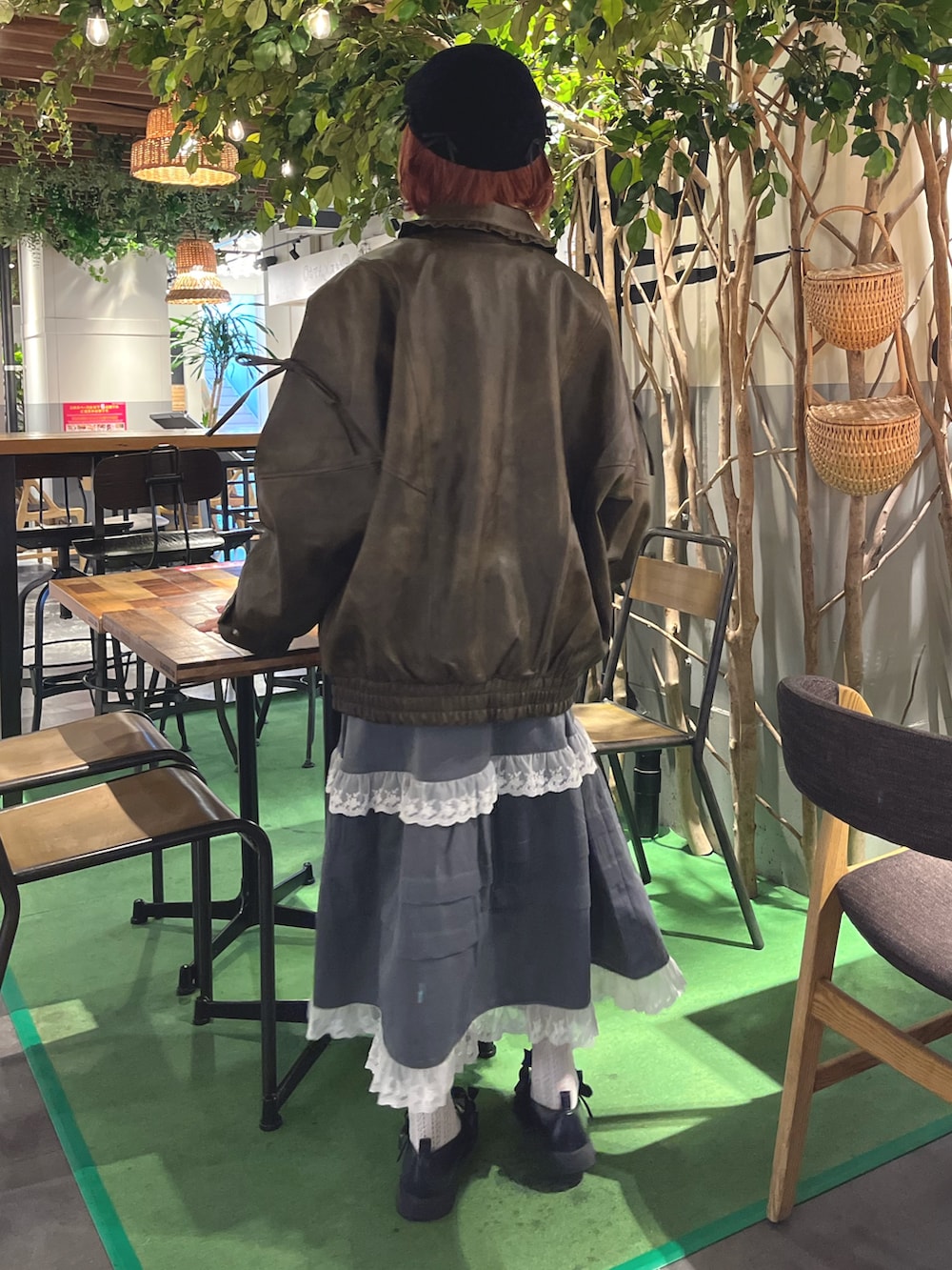 ブラウン系のブルゾン、ブルー系のニット/セーター、グレー系のスカートを着用したレディースの秋コーディネートの4枚目の写真