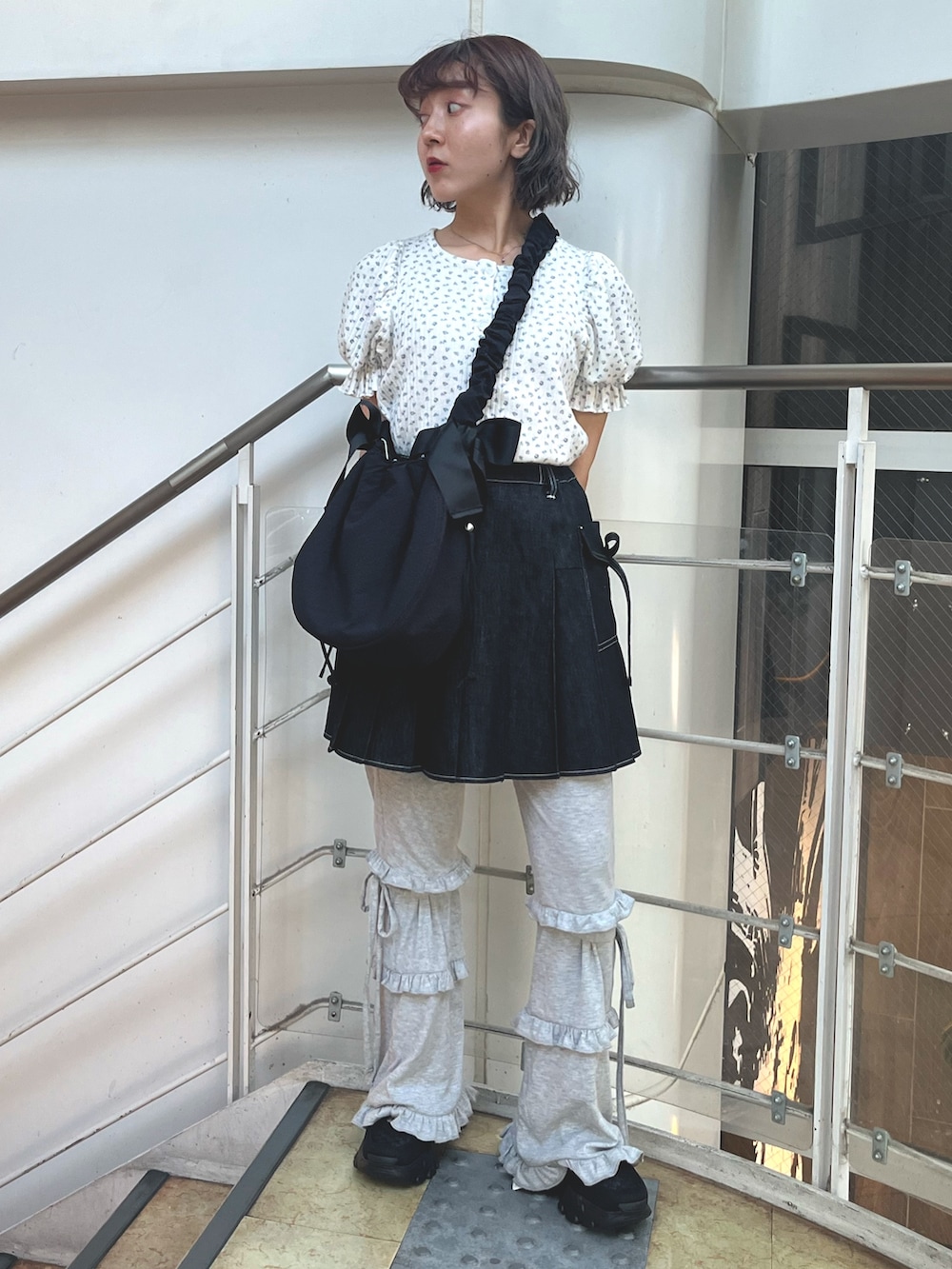 ブラック系のスカート、グレー系のスウェットパンツ、ブラック系のスニーカーを着用したレディースの夏コーディネートの2枚目の写真