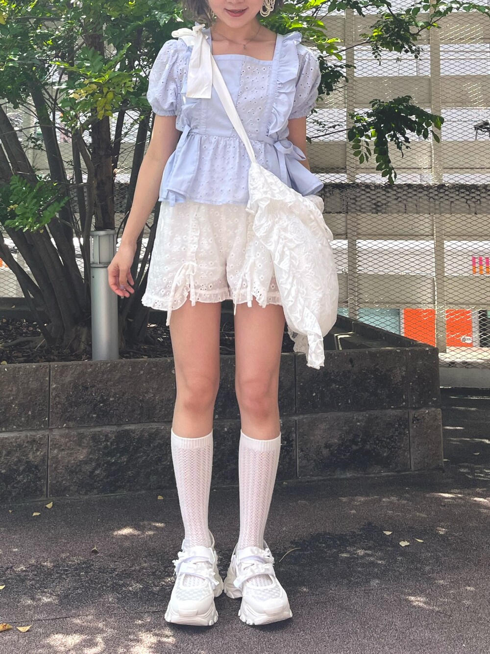 ブルー系のシャツ/ブラウス、ホワイト系のチノパンツ、ホワイト系のスニーカーを着用したレディースの夏コーディネートの2枚目の写真