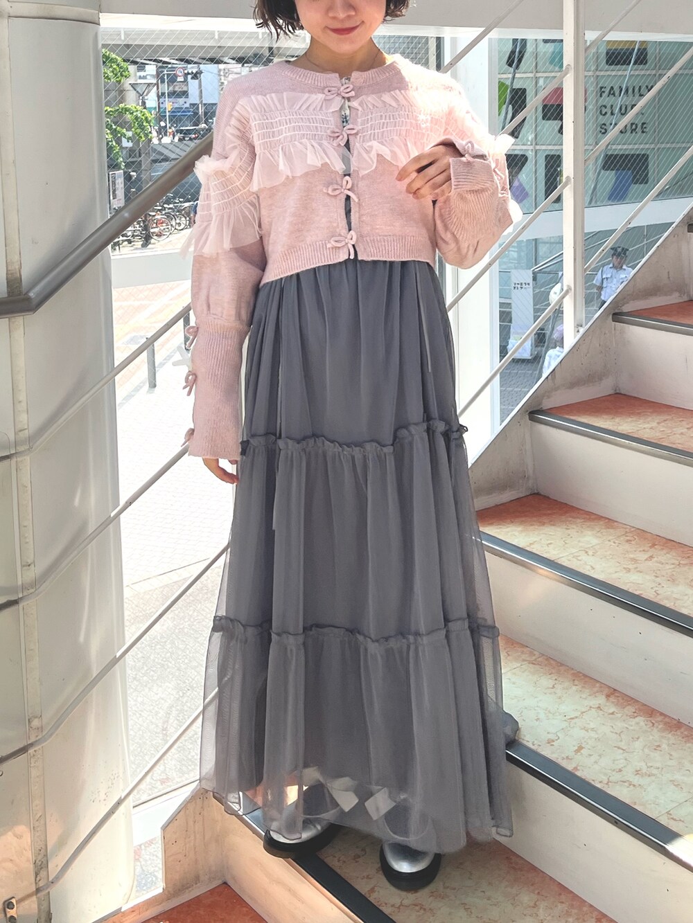 グレー系のワンピース、ピンク系のカーディガン/ボレロ、ホワイト系のTシャツ/カットソーを着用したレディースの秋コーディネートの2枚目の写真