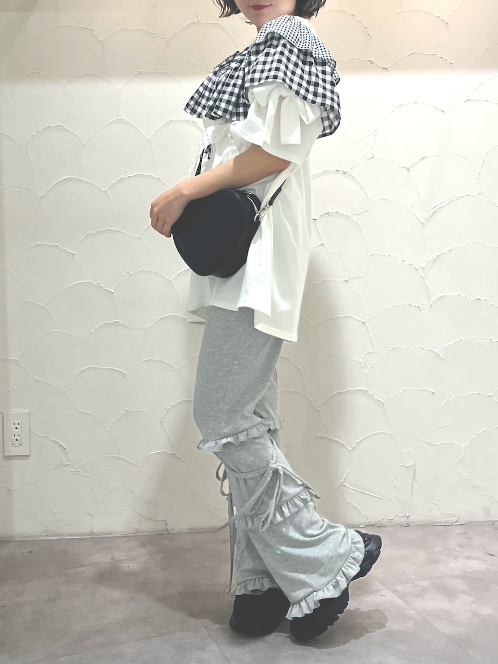 ホワイト系のTシャツ/カットソー、ブラック系のショルダーバッグ、グレー系のスウェットパンツを着用したレディースの春コーディネートの3枚目の写真