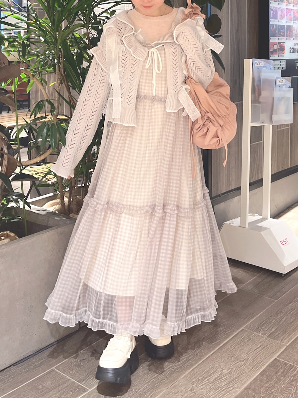 グレー系のカーディガン/ボレロ、ピンク系のニット/セーター、ベージュ系のワンピースを着用したレディースの春コーディネートの2枚目の写真