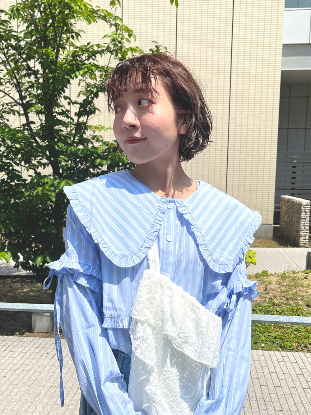 ブルー系のシャツ/ブラウス、ホワイト系のトートバッグ、ブルー系のデニムパンツを着用したレディースの夏コーディネートの4枚目の写真