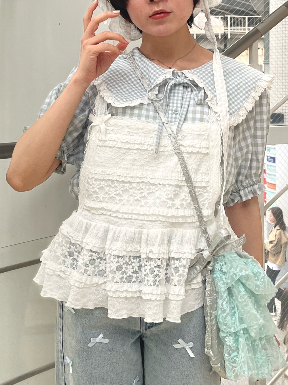 ホワイト系のキャミソール、グリーン系のシャツ/ブラウス、ブルー系のショルダーバッグを着用したレディースの春コーディネートの4枚目の写真