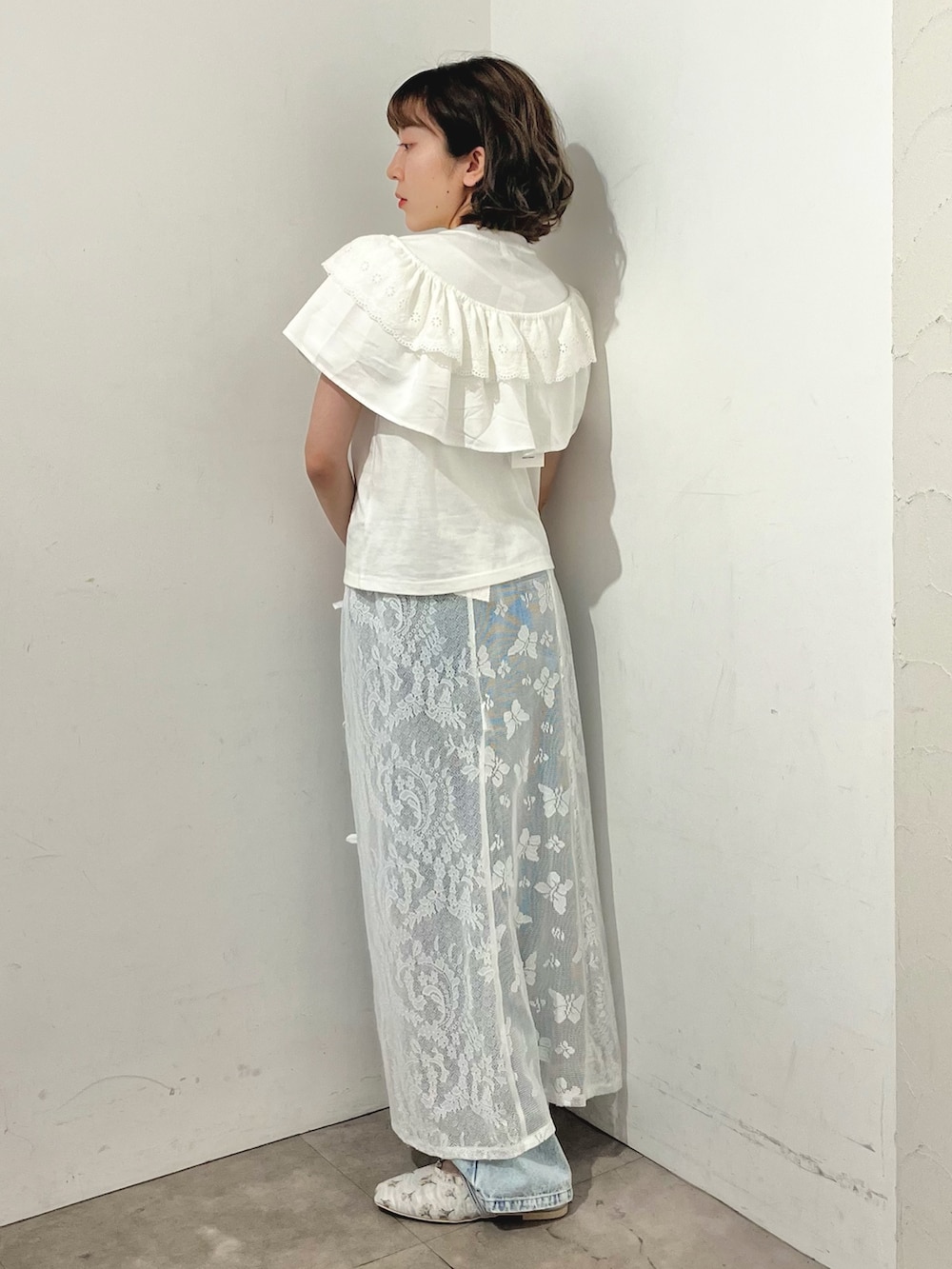 ホワイト系のスカート、ホワイト系のTシャツ/カットソー、ブルー系のデニムパンツを着用したレディースの春コーディネートの7枚目の写真