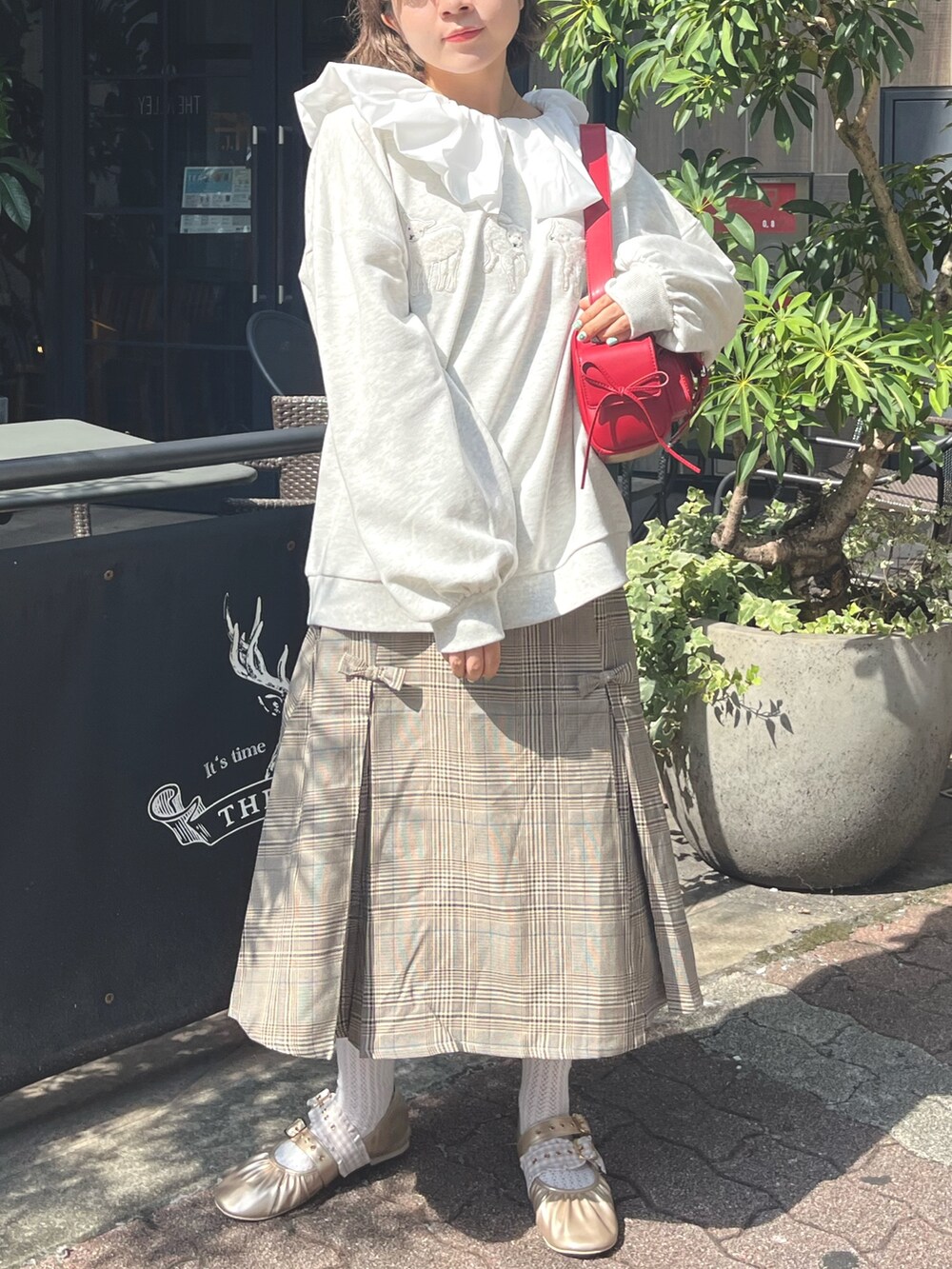 グレー系のスウェット、ホワイト系のシャツ/ブラウス、レッド系のショルダーバッグを着用したレディースの秋コーディネートの2枚目の写真