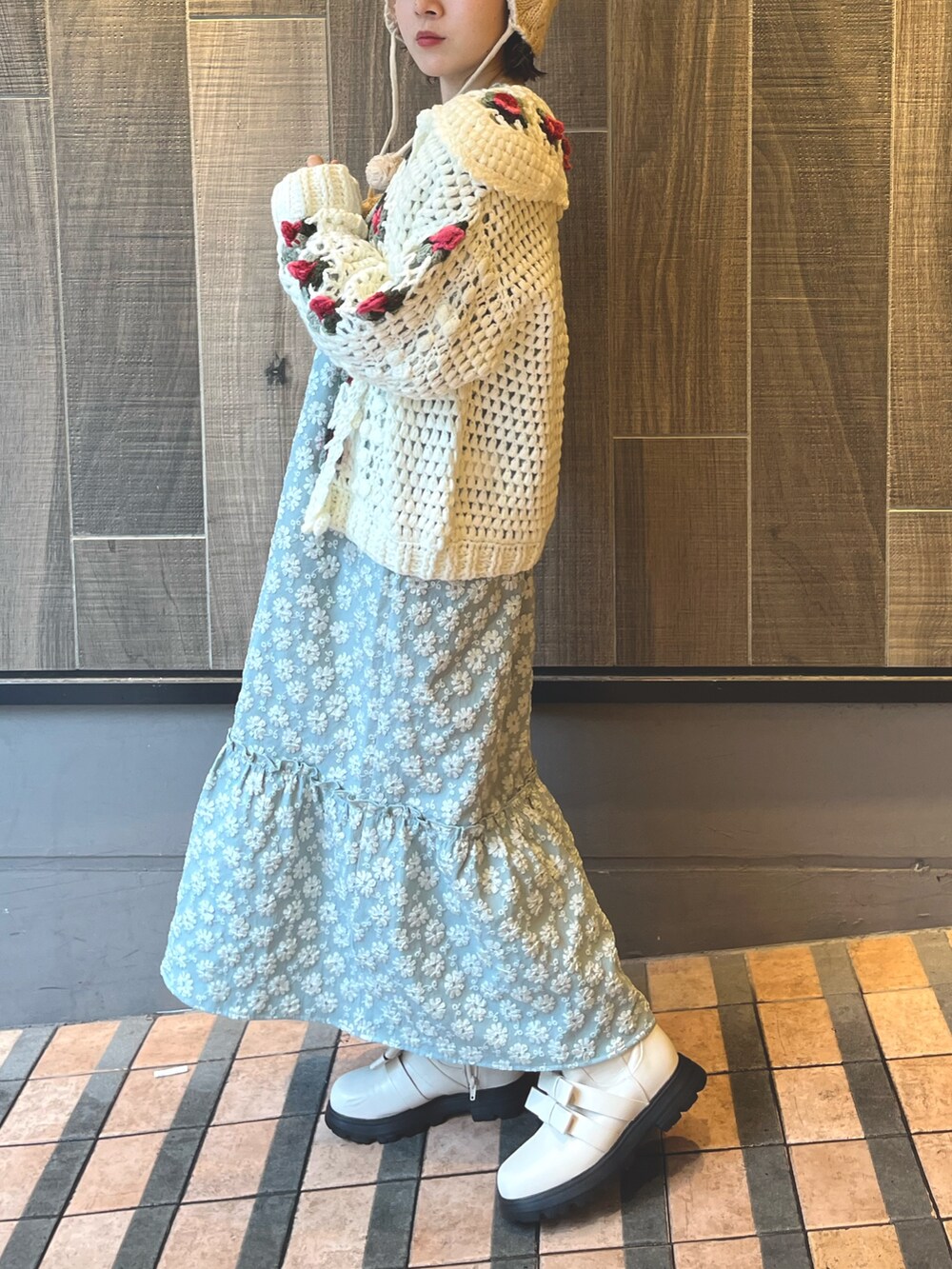 グリーン系のワンピース、ホワイト系のカーディガン/ボレロ、ホワイト系のブーツを着用したレディースの秋コーディネートの3枚目の写真