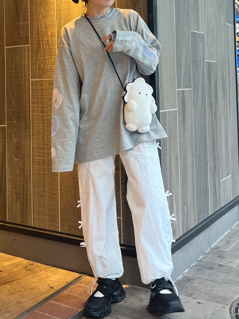 ホワイト系のショルダーバッグ、グレー系のTシャツ/カットソー、ブルー系のTシャツ/カットソーを着用したレディースの冬コーディネートの7枚目の写真