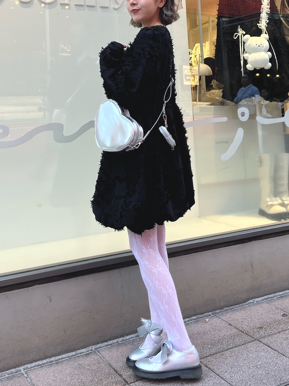 シルバー系のバレエシューズ、ブラック系のワンピース、シルバー系のショルダーバッグを着用したレディースの秋コーディネートの3枚目の写真