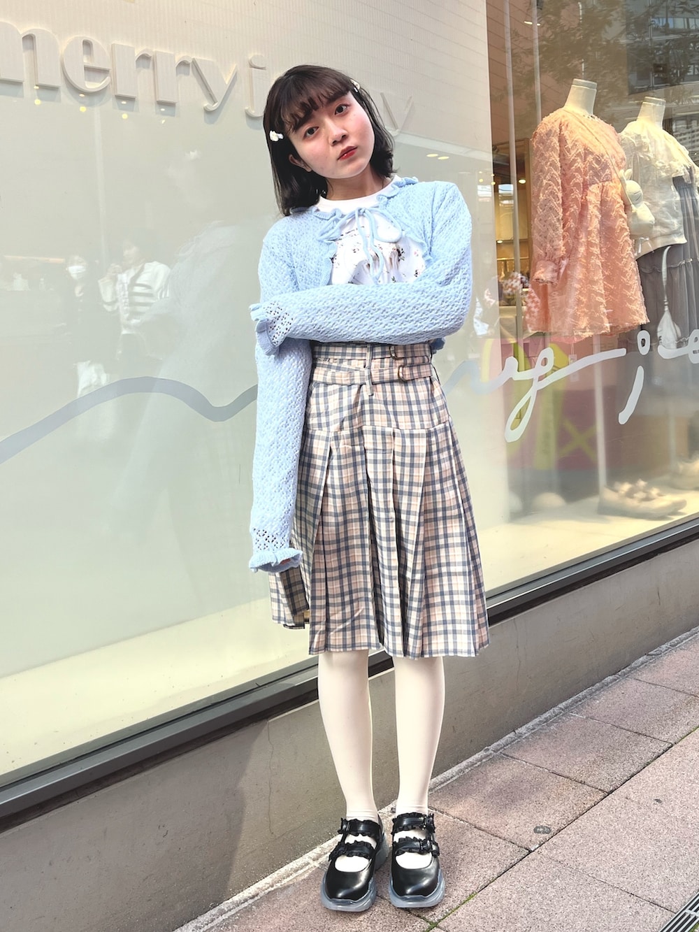 ベージュ系のスカート、ブルー系のカーディガン/ボレロ、ホワイト系のTシャツ/カットソーを着用したレディースの春コーディネートの2枚目の写真