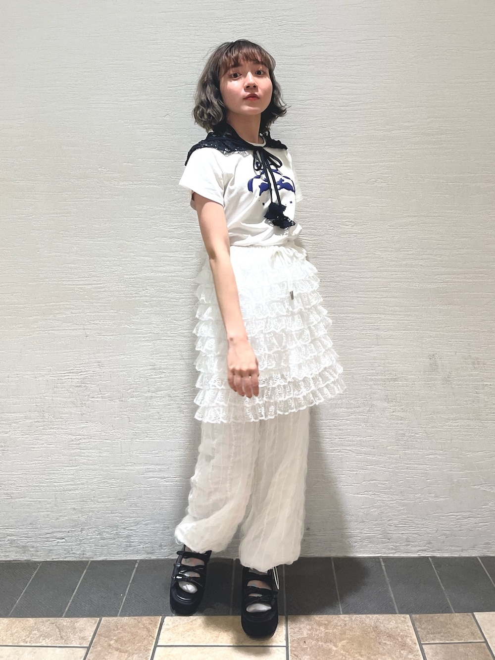 ホワイト系のスカート、ホワイト系のカーゴパンツ、ブラック系のサンダルを着用したレディースの春コーディネートの2枚目の写真