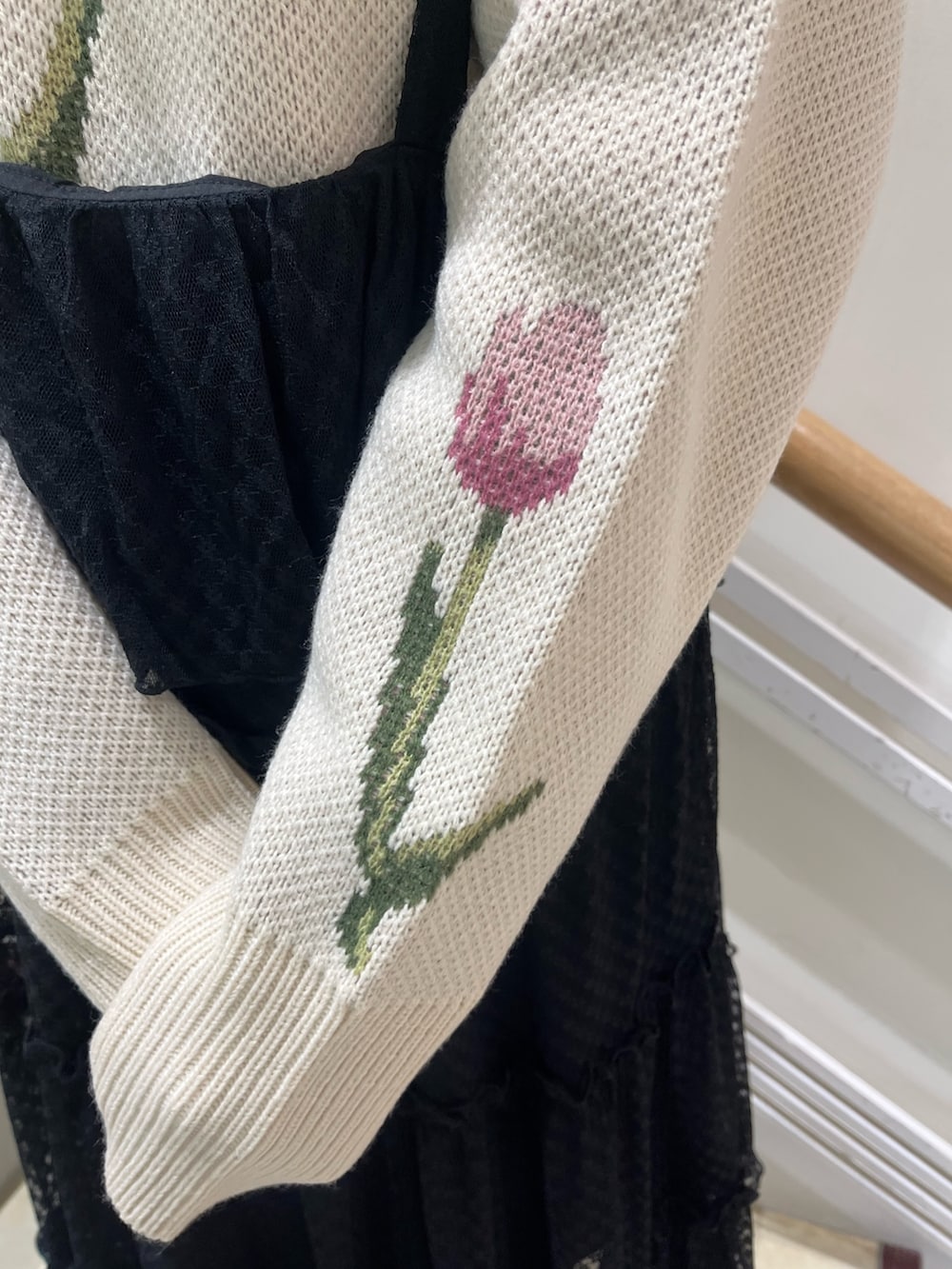 ブラック系のワンピース、ホワイト系のニット/セーター、ブラック系のパンプスを着用したレディースの冬コーディネートの7枚目の写真