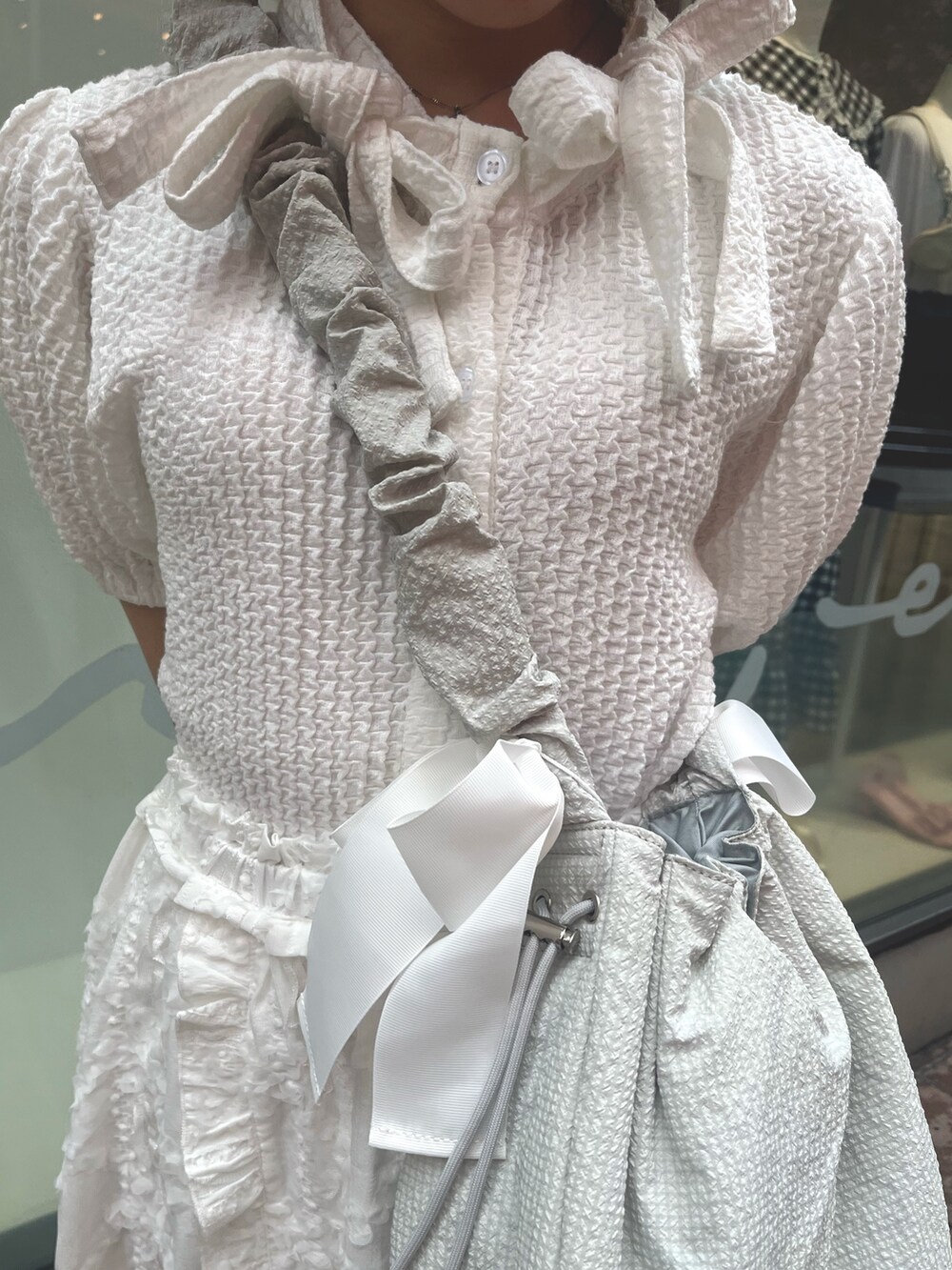 ホワイト系のスカート、ホワイト系のシャツ/ブラウス、グリーン系のショルダーバッグを着用したレディースの夏コーディネートの7枚目の写真