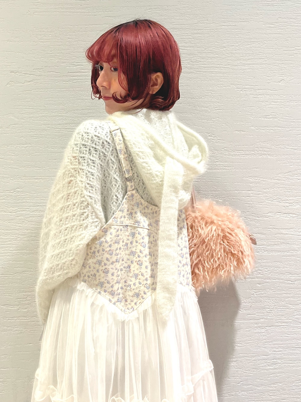 ピンク系のボストンバッグ、ホワイト系のニット/セーター、ホワイト系のワンピースを着用したレディースの秋コーディネートの8枚目の写真