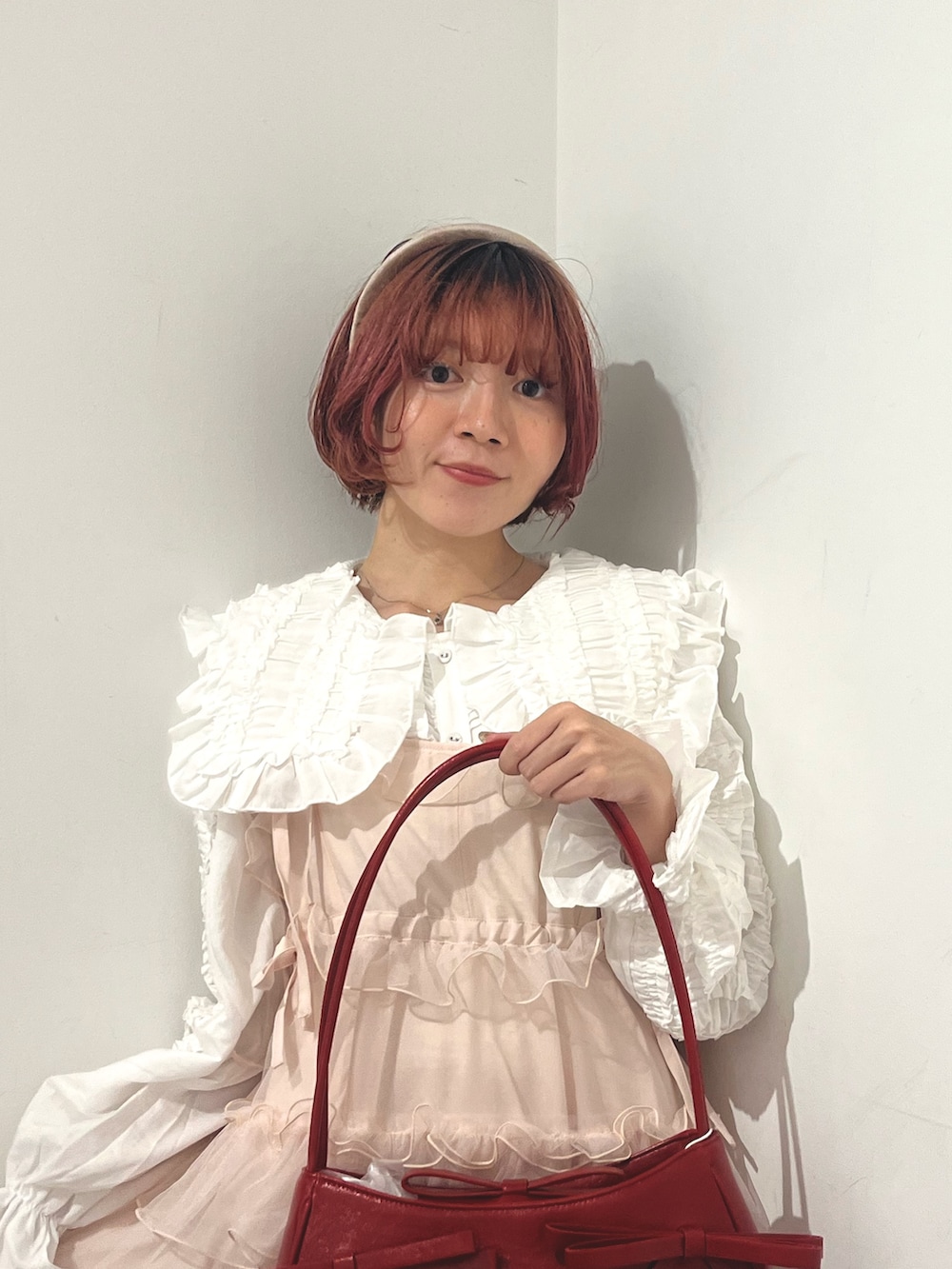 ホワイト系のシャツ/ブラウス、ピンク系のワンピース、レッド系のハンドバッグを着用したレディースの秋コーディネートの5枚目の写真