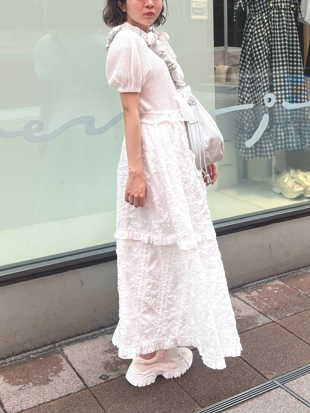 ホワイト系のスカート、ホワイト系のシャツ/ブラウス、グリーン系のショルダーバッグを着用したレディースの夏コーディネートの3枚目の写真