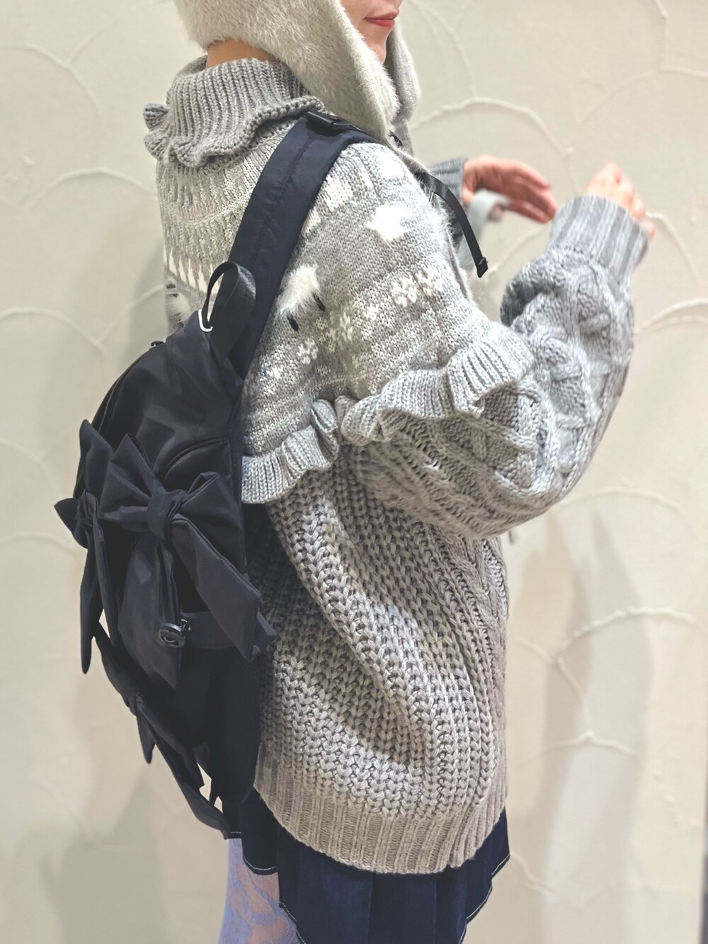 ホワイト系のローファー、グレー系のニット/セーター、ブラック系のショルダーバッグを着用したレディースの冬コーディネートの5枚目の写真