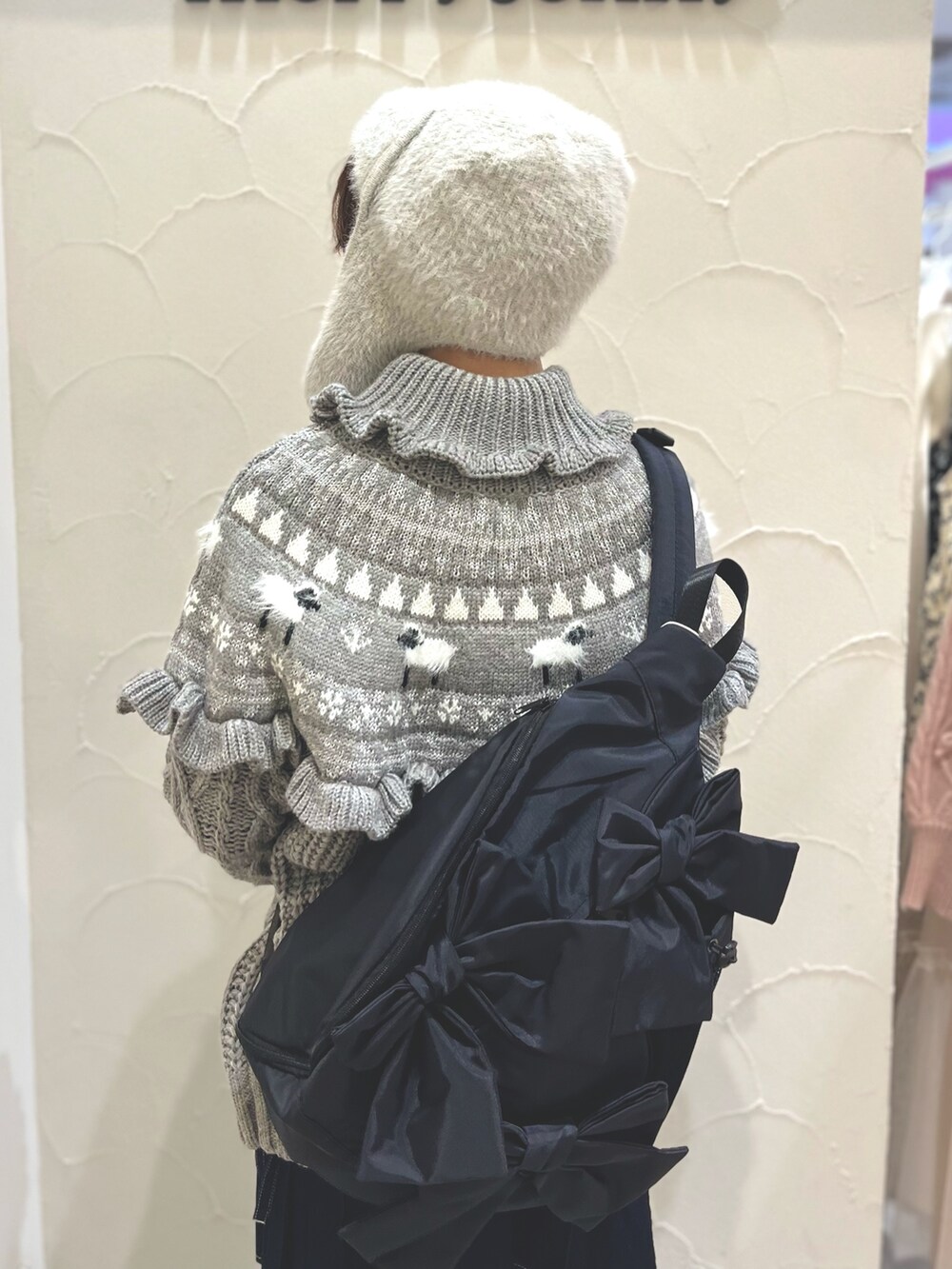 ホワイト系のローファー、グレー系のニット/セーター、ブラック系のショルダーバッグを着用したレディースの冬コーディネートの6枚目の写真