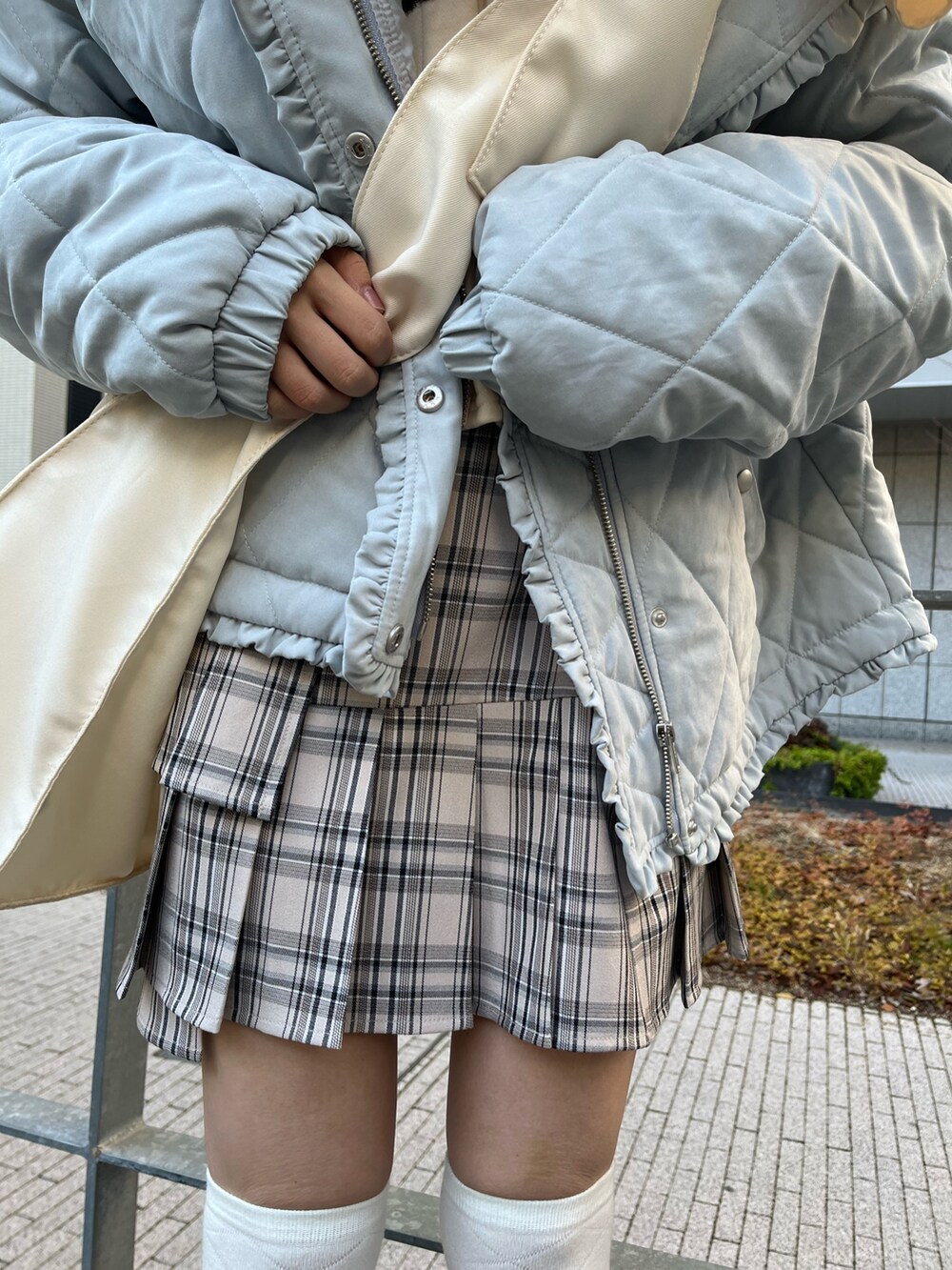 ブルー系のダウンジャケット/コート、ベージュ系のスカート、ホワイト系のトートバッグを着用したレディースの冬コーディネートの6枚目の写真