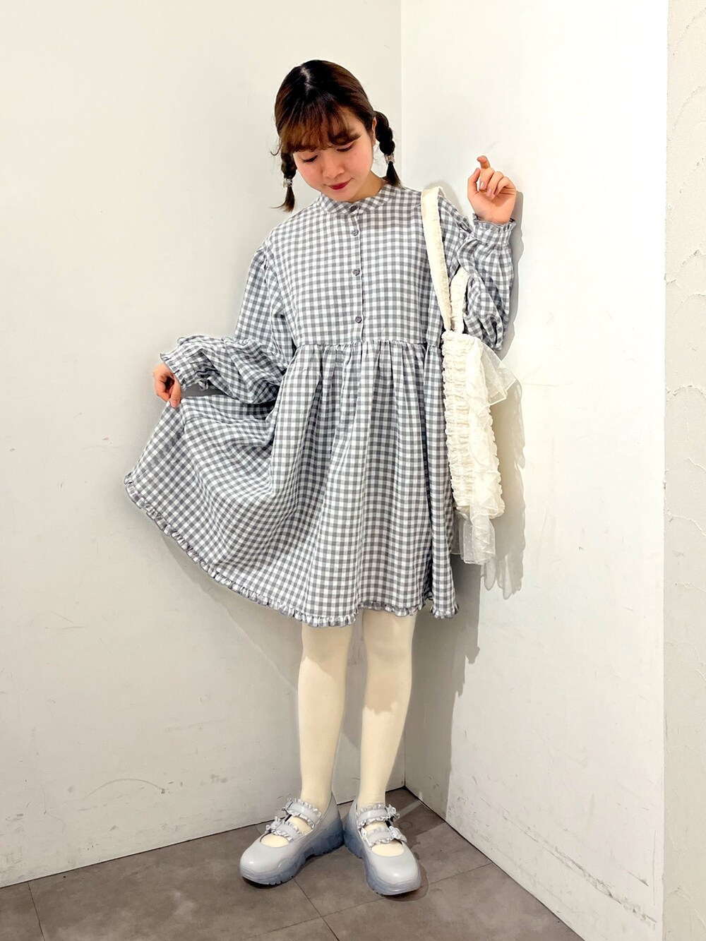 グレー系のワンピース、ホワイト系のトートバッグ、ブルー系のスニーカーを着用したレディースの春コーディネートの6枚目の写真