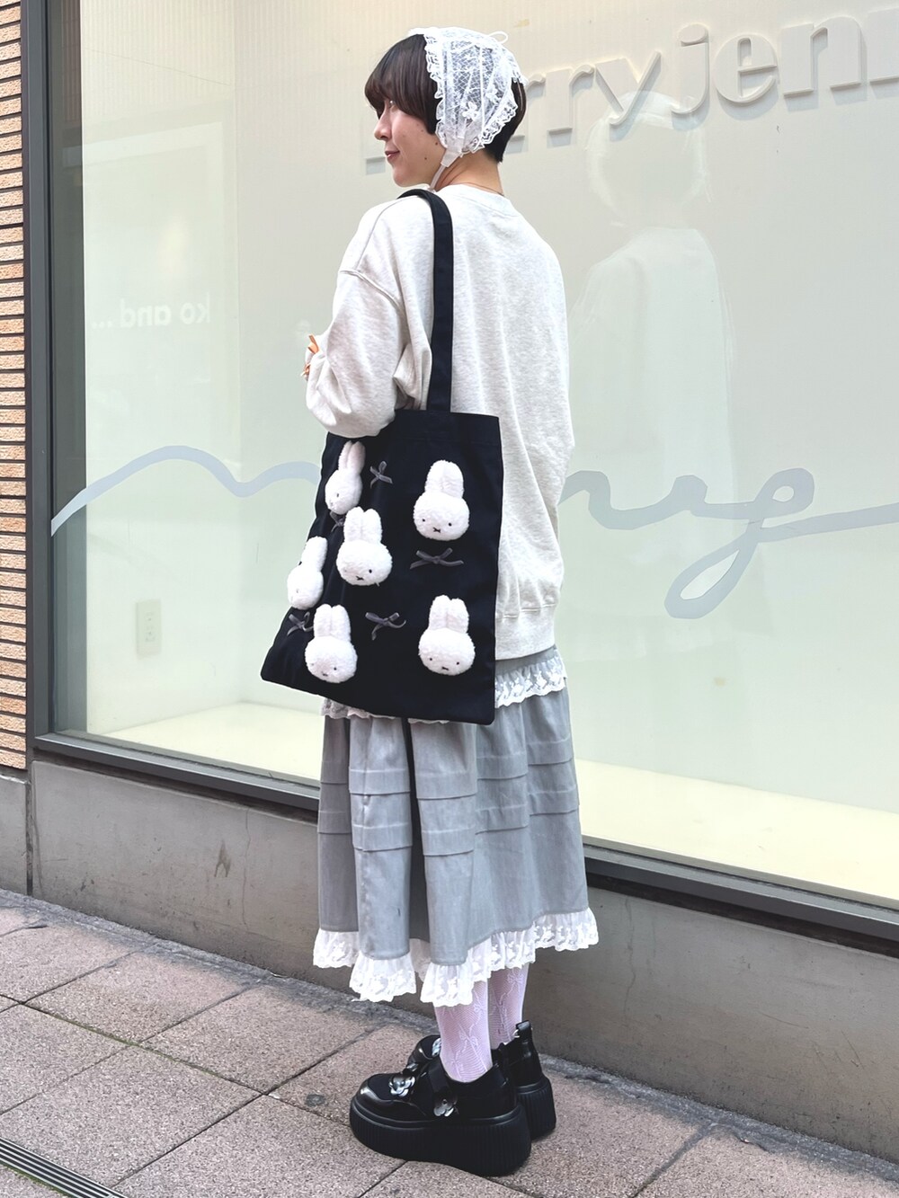 グレー系のスウェット、グレー系のスカート、ブラック系のスニーカーを着用したレディースの冬コーディネートの4枚目の写真