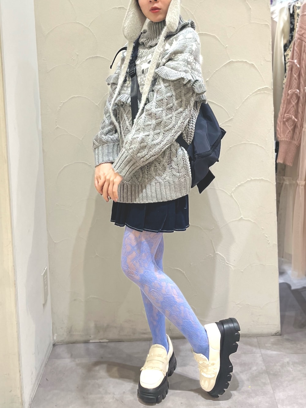 ホワイト系のローファー、グレー系のニット/セーター、ブラック系のショルダーバッグを着用したレディースの冬コーディネートの2枚目の写真