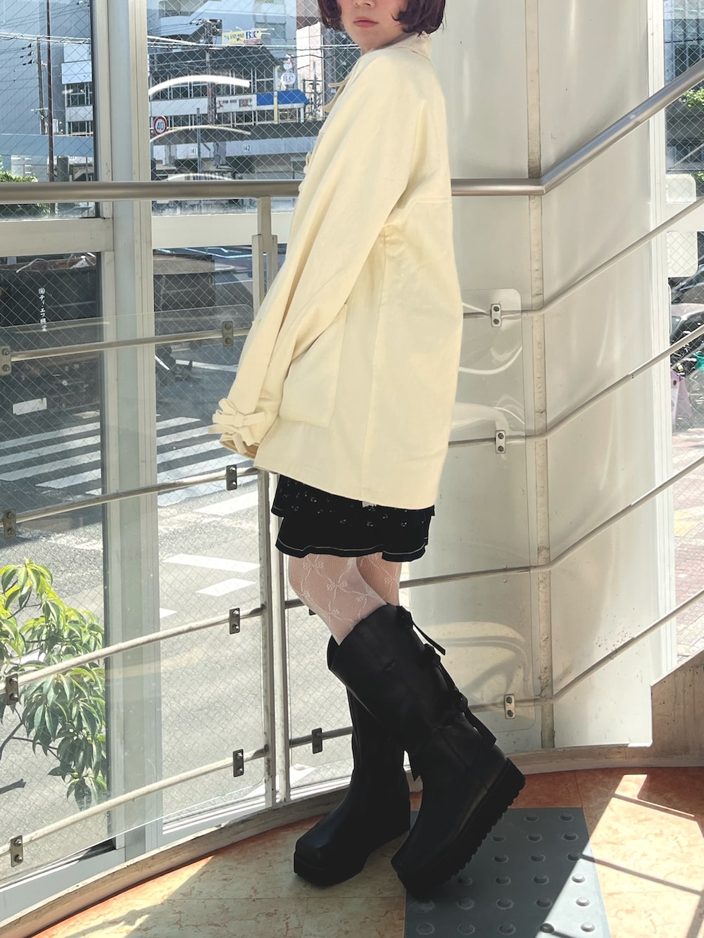 ブラック系のチュニック、イエロー系のTシャツ/カットソー、ホワイト系のブルゾンを着用したレディースの秋コーディネートの6枚目の写真