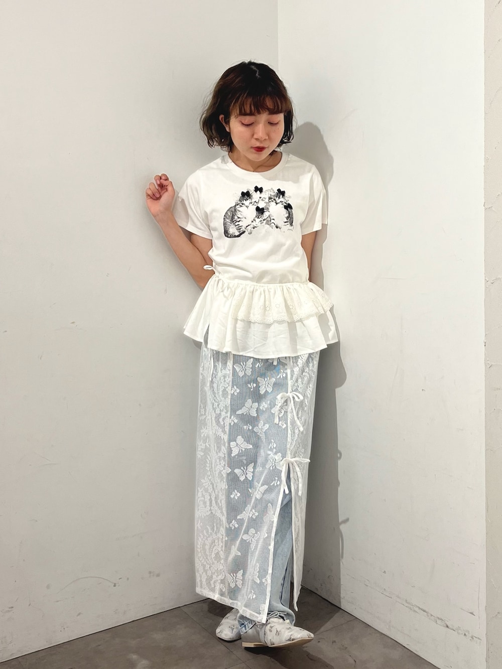 ホワイト系のスカート、ホワイト系のTシャツ/カットソー、ブルー系のデニムパンツを着用したレディースの春コーディネートの5枚目の写真