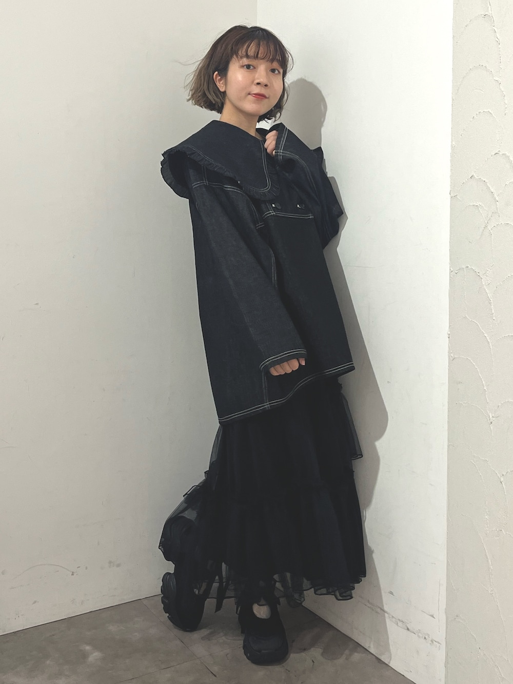 ホワイト系のトートバッグ、ブルー系のデニムジャケット、ブラック系のスカートを着用したレディースの秋コーディネートの4枚目の写真