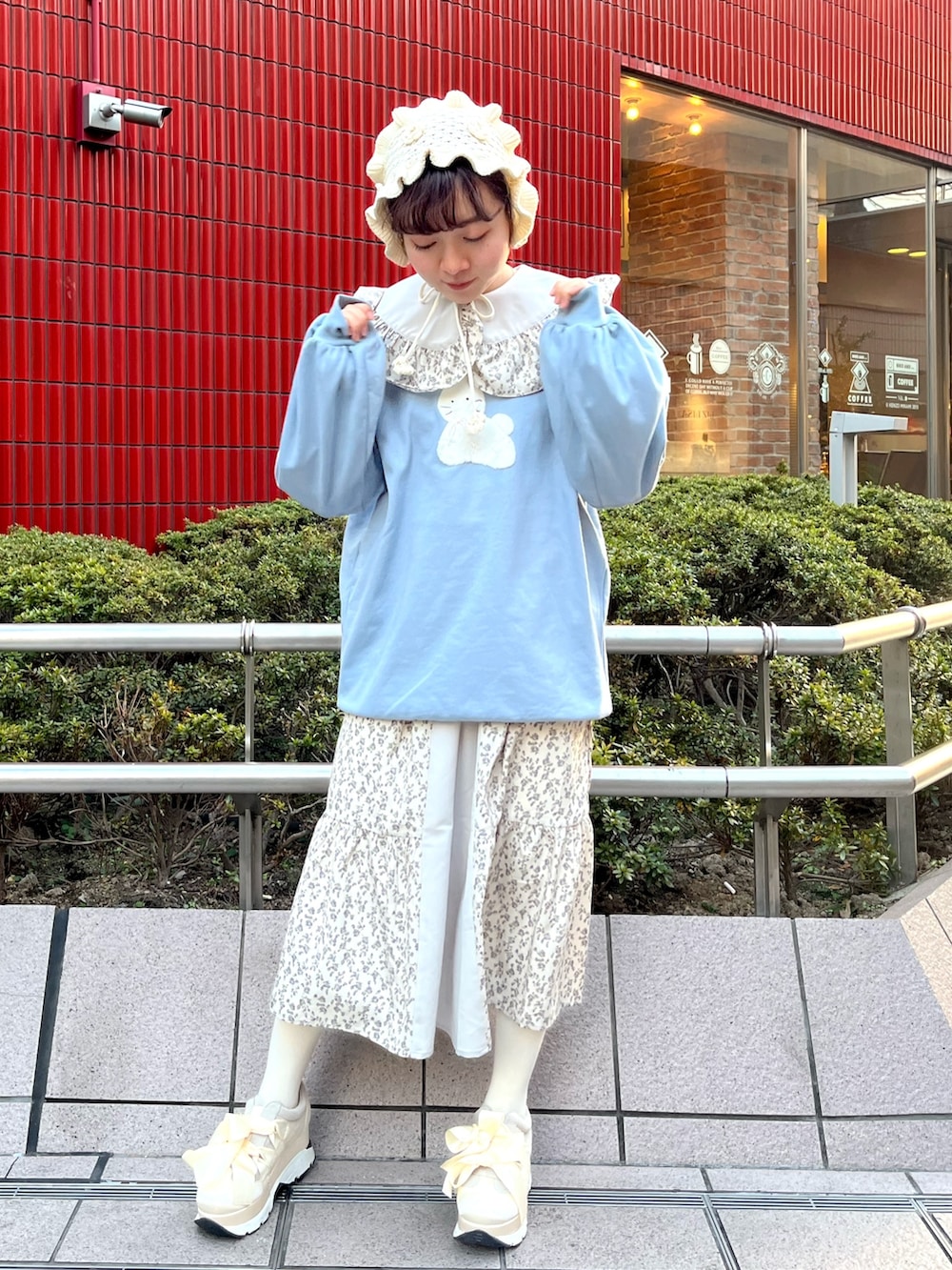 ブルー系のスウェット、ブルー系のワンピース、ホワイト系のスニーカーを着用したレディースの冬コーディネートの2枚目の写真