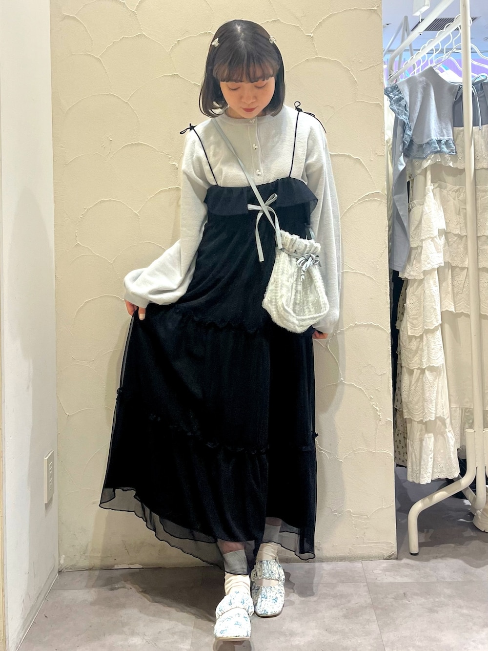 ブラック系のワンピース、ブルー系のショルダーバッグ、ホワイト系のパンプスを着用したレディースの春コーディネートの2枚目の写真