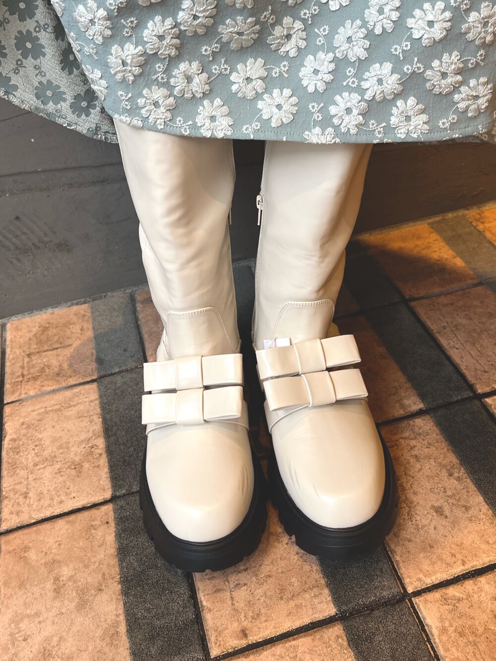 グリーン系のワンピース、ホワイト系のカーディガン/ボレロ、ホワイト系のブーツを着用したレディースの秋コーディネートの9枚目の写真