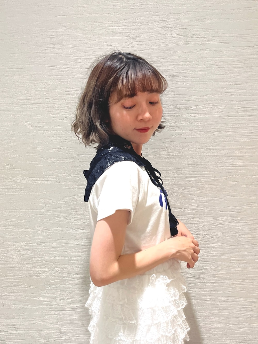 ホワイト系のスカート、ホワイト系のカーゴパンツ、ブラック系のサンダルを着用したレディースの春コーディネートの5枚目の写真