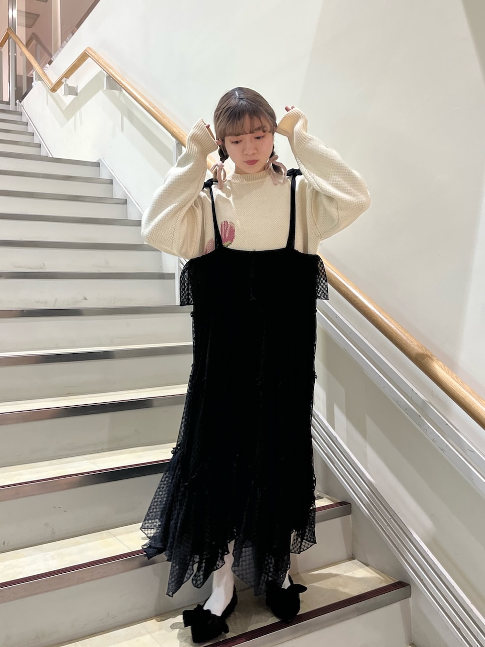 ブラック系のワンピース、ホワイト系のニット/セーター、ブラック系のパンプスを着用したレディースの冬コーディネートの2枚目の写真