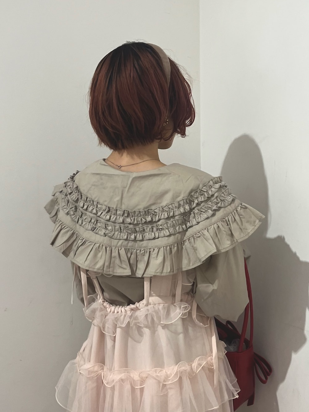 ベージュ系のシャツ/ブラウス、ピンク系のワンピース、レッド系のハンドバッグを着用したレディースの秋コーディネートの8枚目の写真